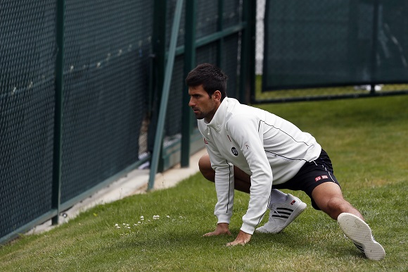 Novak Djokovic of Serbia stretches before a practice session at Wimbledon in London June 23, 2013. REUTERS/Stefan Wermuth (BRITAIN - Tags: SPORT TENNIS)
